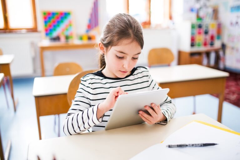 girl,sitting,at,desk,using,tablet,during