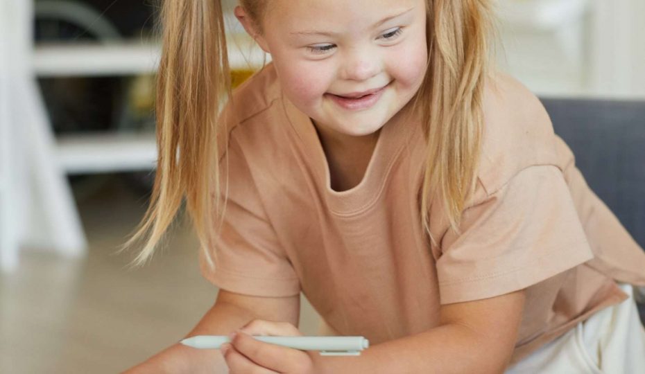 vertical,portrait,of,cute,blonde,girl,with,down,syndrome,drawing