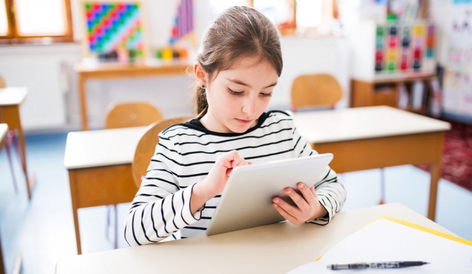 girl,sitting,at,desk,using,tablet,during